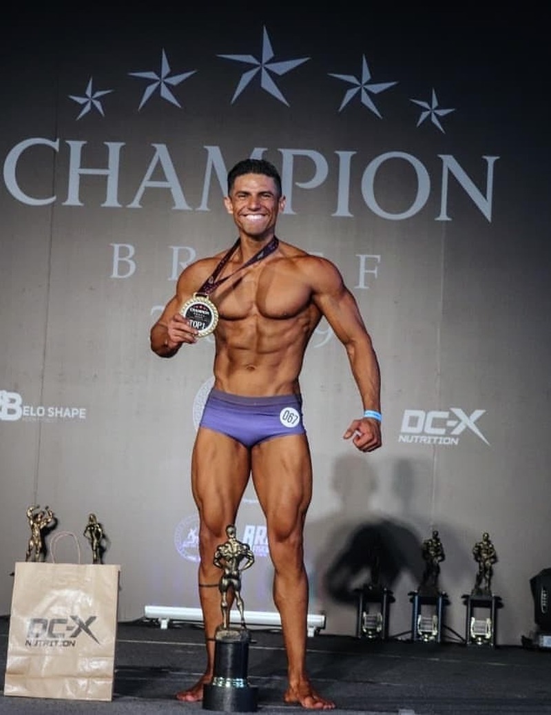 Maurício Gimenez no palco do Champion Brief com medalha e troféu